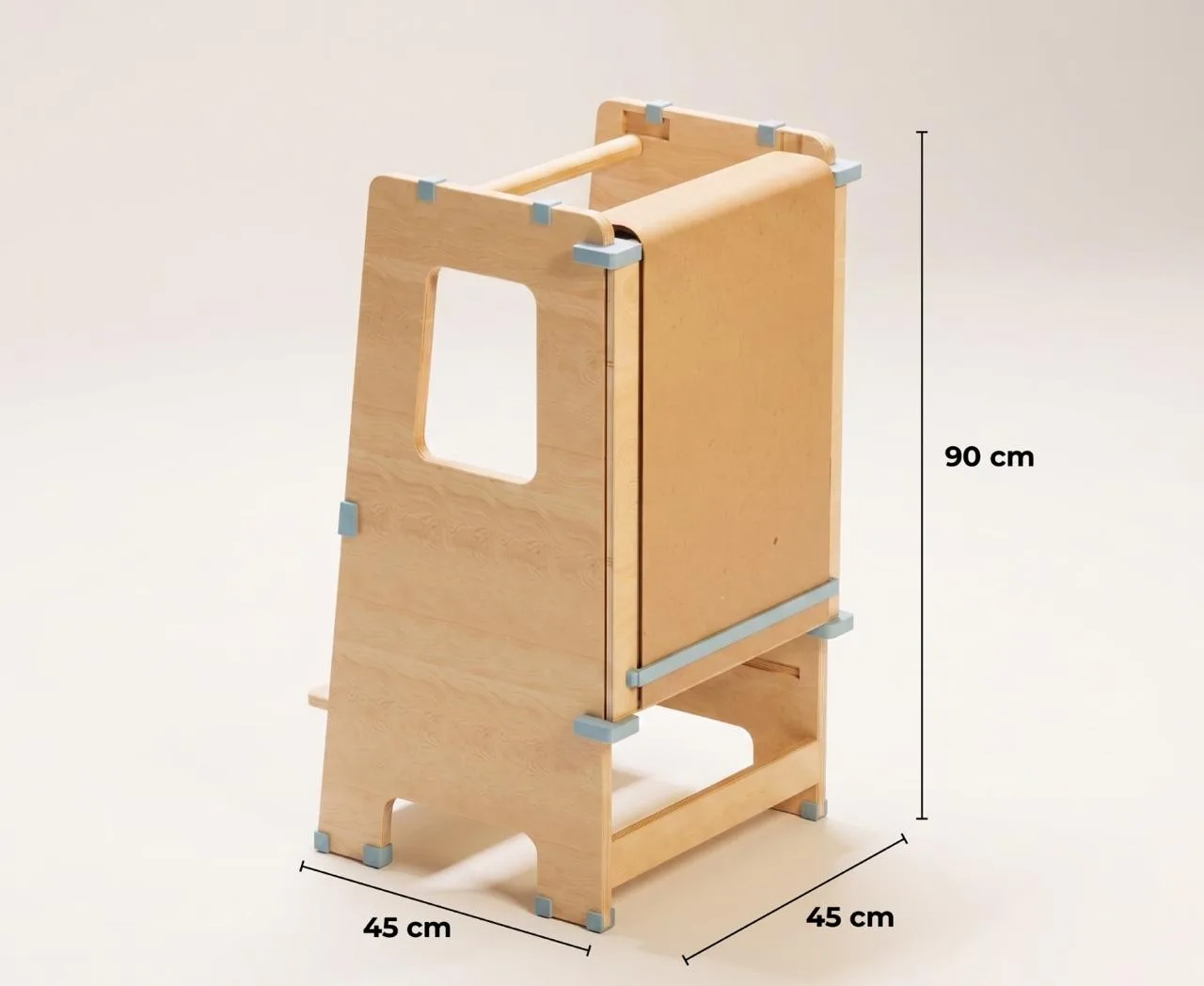 Torre de Aprendizaje en madera clara con cotas de medida marcadas: 90 cm de alto y base de 45 por 45 cm, vista de tres cuartos sobre fondo color crema.